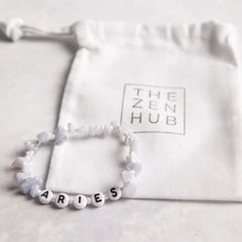 Load image into Gallery viewer, Aries crystal healing bracelet in blue lace agate position against white THE ZEN HUB bag