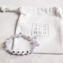 Load image into Gallery viewer, Hope crystal healing bracelet in blue lace agate position against white THE ZEN HUB bag