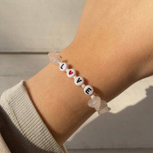 Load image into Gallery viewer, Rose quartz crystal gemstone bracelet with beaded letter spelling out the word 'LOVE'. The letter O in the word has been replaced with a love heart bead