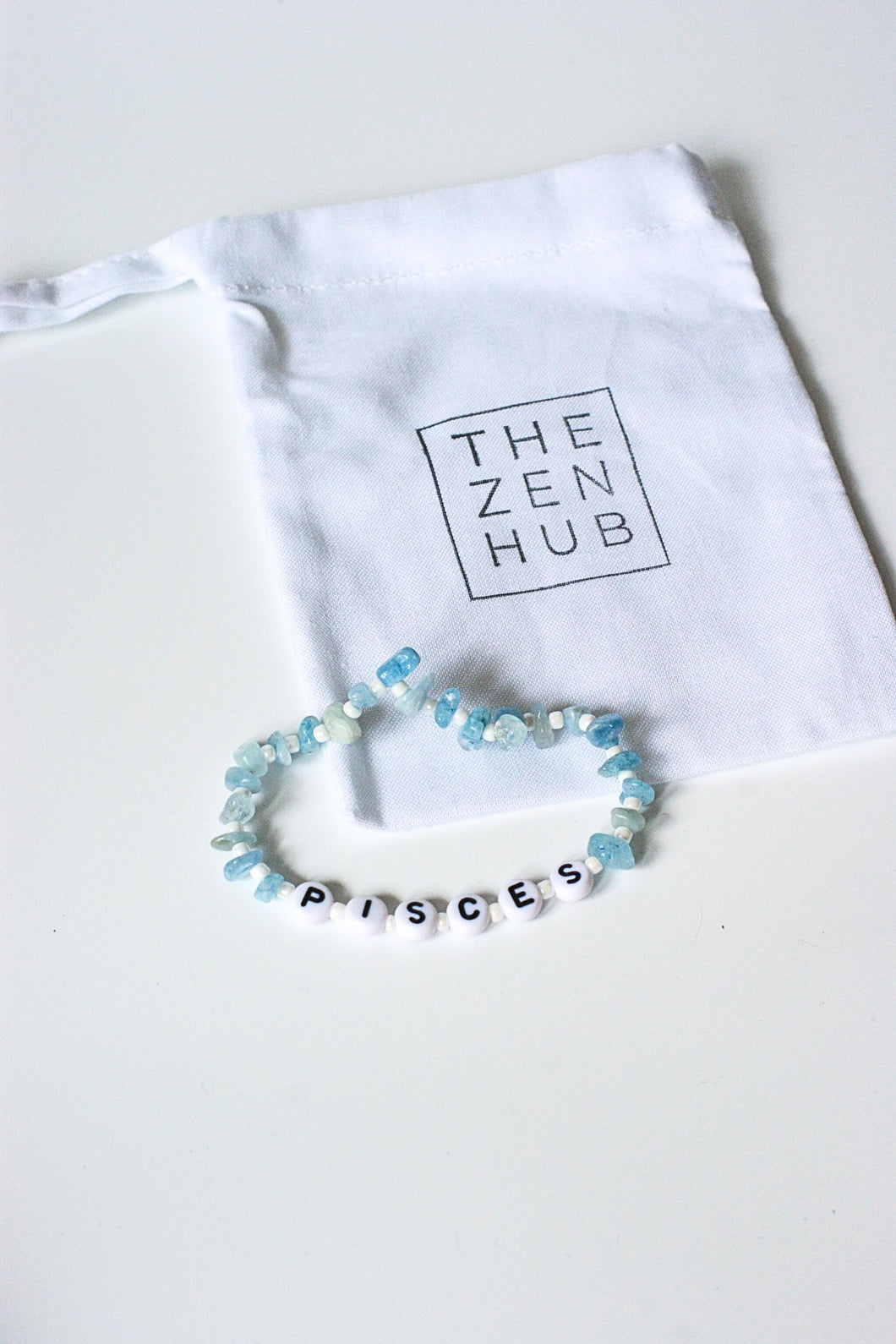 Pisces star sign crystal bracelet in aquamarine led on white cotton bag 